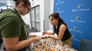 UCI-OC Alliance team member helps at La Bienvenida to welcome new Latino students to UCI.